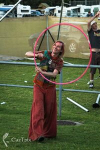 Trevor joyfully playing with a hula hoop outdoors, having fun at the Maleney music festival.