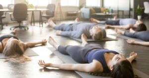 Office workers practising kriya relaxation techniques for workplace wellness and stress relief.