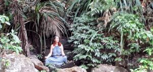 Penelope meditating peacefully at Protester Falls, surrounded by lush Australian rainforest.