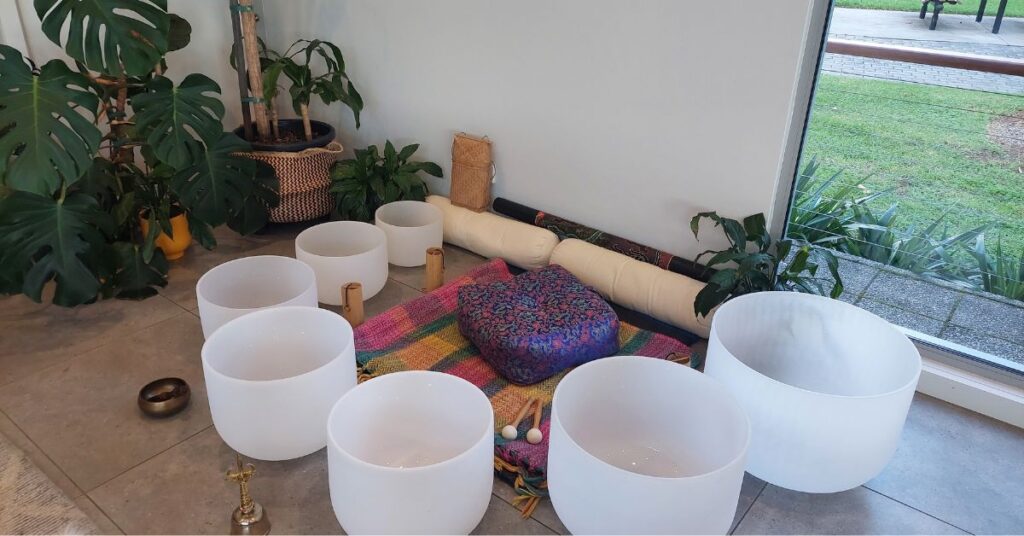 Seven frosted crystal singing bowls arranged with deliberate acoustic intention for sound healing.