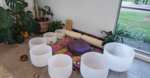 Seven frosted crystal singing bowls arranged with deliberate acoustic intention for sound healing.